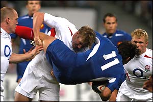 England's players tackle France's Christophe Dominici