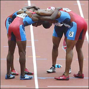 The US 4x100m relay team form a huddle after taking the gold medal