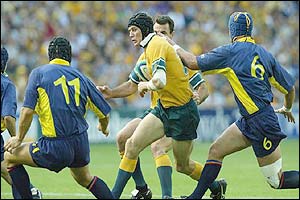 Australia's Stephen Larkham takes on the Romanian defence