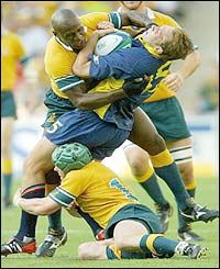 Romania Danut Dumbrava is tackled by two Australians 