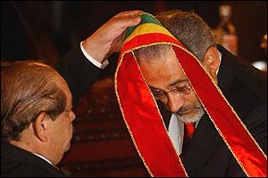 Bolivian Vice President Carlos Mesa is handed the sash of the Bolivian presidency in a swearing-in ceremony