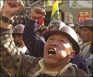 Miners still in their work gear raise their fists in the air in celebration as rumours emerge of the president's resignation