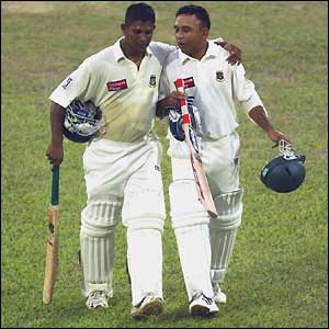 Bangladesh batsmen Mushfiqur Rahman and Khaled Mammud leave the pitch after bad light stops play on day four