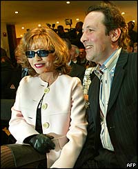 Joan Collins and husband Percy Gibson at JFK airport