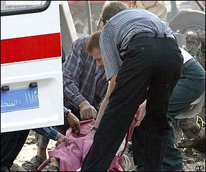 A body is carried out of the ICRC building by ambulance workers following the blast 
