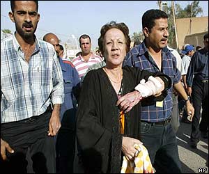 Woman with injured hand is escorted away to seek medical treatment 