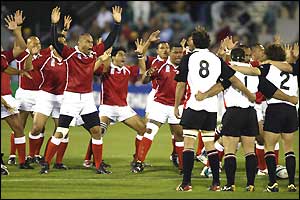 The Tongan team perform the sipi tau as the Canadians watch on