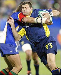 Romanian centre Valentin Maftei is tackled by Namibian flanker Schalk van der Merwe 