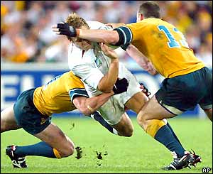 Jonny Wilkinson is tackled by two Wallabies