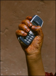 Henna-painted hand holding a cell phone