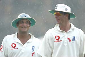 Mark Butcher and Michael Vaughan leave the pitch as rains stops play
