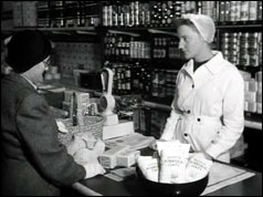 Lady buying tea from a grocer's shop
