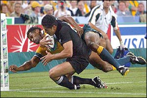 New Zealand's Mils Muliaina is tackled by Lote Tuqiri on the try-line