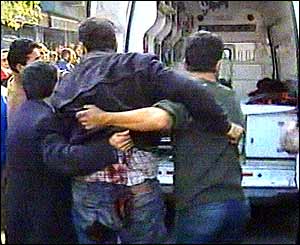 Injured man being helped at scene after bomb blast