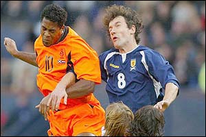 Holland's Patrick Kluivert jumps for a header with Christian Dailly