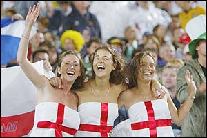 Three England fans wave to the camera