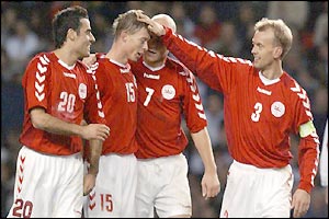 Jon Dahl Tomasson is congratulated by his team-mates after scoring a late winner for Denmark