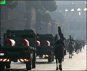 Presidential guards escort army trucks, each carrying two caskets covered in the Italian flag, towards St Paul Basilica 