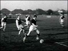 Football match, player in dark shirt has the ball