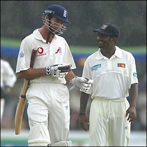 Michael Vaughan talks to Muttiah Muralitharan as the players leave the field due to rain