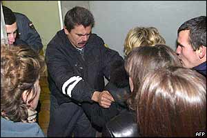 A hospital guard pushes relatives of injured passengers in a hospital in Yessentuki