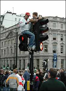 Two fans atop traffic lights next to Trafalgar Square