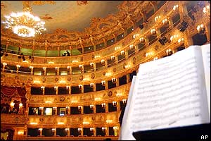 Side view showing upper tiers of theatre seats with music book in foreground
