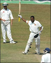 Thilan Samaraweera raises his bat to the crowd after reaching his hundred