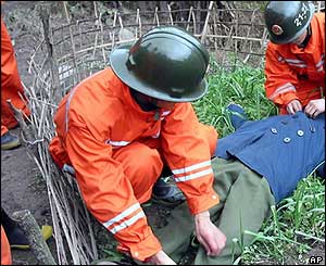 Fire-fighters tidy the clothes of a man who died in the explosion