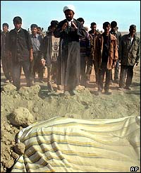 Clergyman praying at mass graves