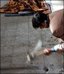 A young Iranian boy digs a grave for his dead sister who died in the earthquake