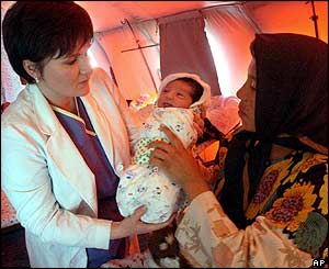 Dr Anna Rubon, gives Mahdeih, who was born on Wednesday at the Ukrainian mobile hospital to her mother Maryam (r)