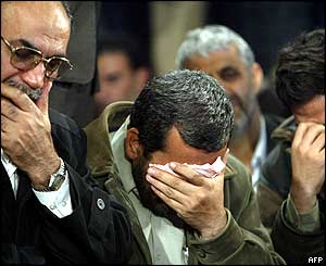 A group of men are overcome with emotion at the memorial service