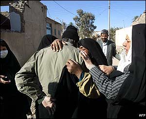 Neighbours embrace as they return to the site of their ruined homes