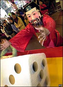 A department store employee in traditional Chinese costume throws dices in Taipei