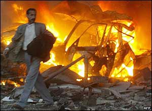 Man walks past burning car after hotel blast 