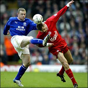 Jamie Carragher (right) gets the ball away from Wayne Rooney