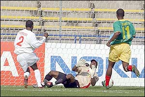 Guinea's striker Pascal Feindounou scores past Mali's goalkeeper Sidibe Mahamadou and defender Djibril Sidibe