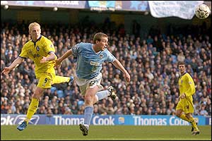 City's Richard Dunne heads the ball away from Mikael Forssell 