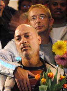 Eric Smith (front) is embraced by his partner Mark Garrett during a reception at San Francisco City Hall 