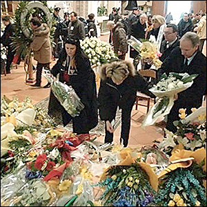 Flowers are laid near the former Tour de France winner's coffin