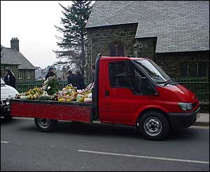 A truck adorned with flowers and wreaths