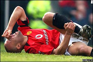 Mickael Silvestre lies on the ground holding his injured leg