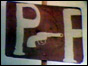 Placard reads PF with image of a gun