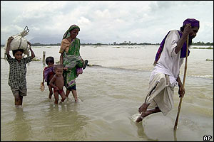A handicapped man with his family wades through floodwater in Assam