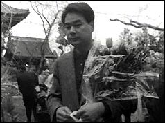 A man carries flowers at the funeral for the Japanese victims