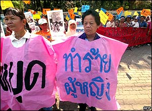 Two Thai women wear banners in a parade near the Parliament House in Bangkok.