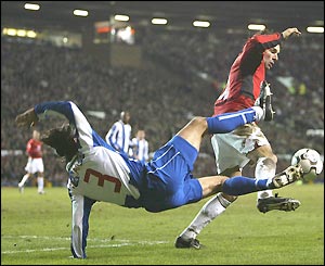 Ruud Van Nistelrooy avoids a high tackle from Pedro Emanuel