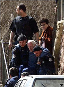 UN police officers carry disabled Serb man from his home in Mitrovica
