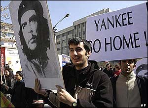 Protesters holding signs saying 
